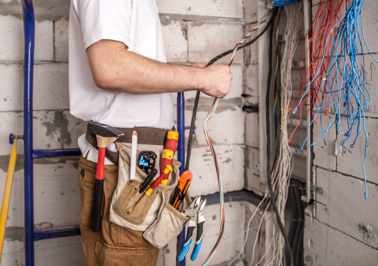 electrician working near board with wires installation connection electrics 768x542